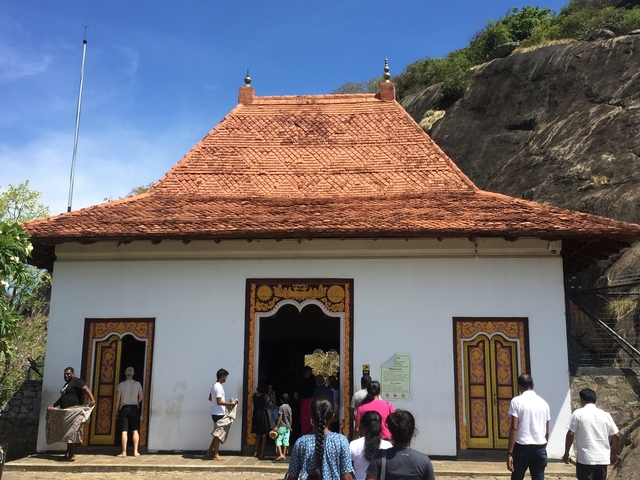Visitors at an entrance of a temple building.