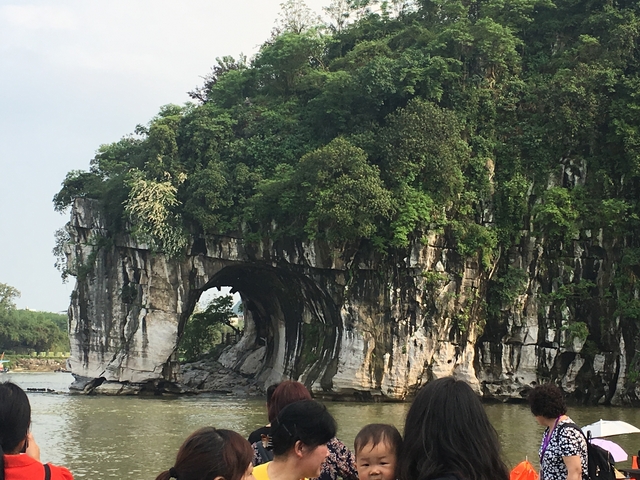 Karst mountain with an arch formation above a river.