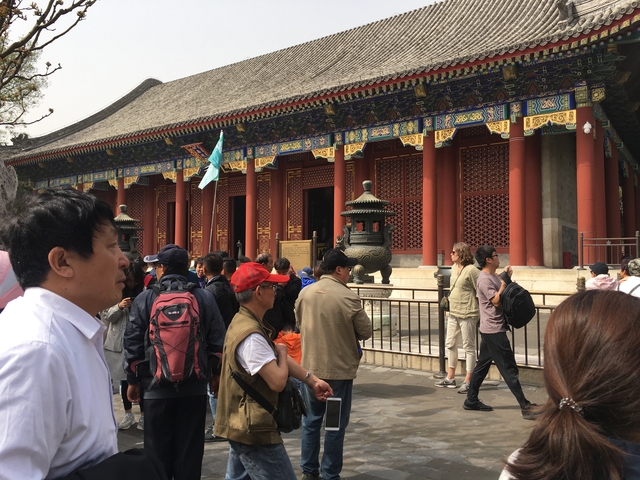       Crowd of people in front of a traditional Chinese building.
  