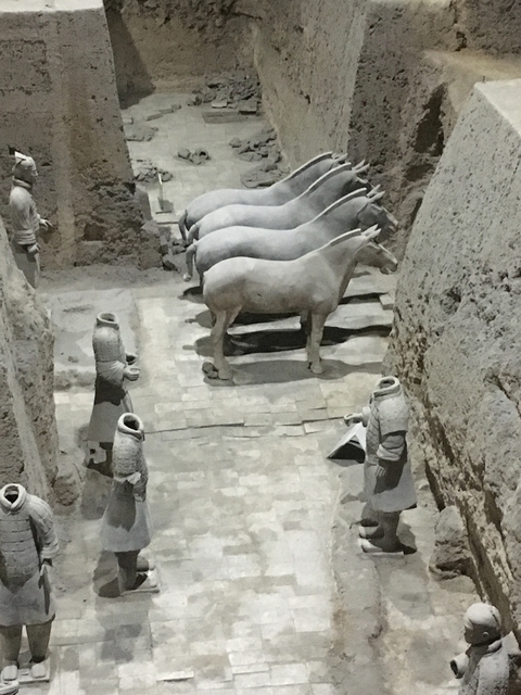 Terracotta Warriors with horses in an excavation site.