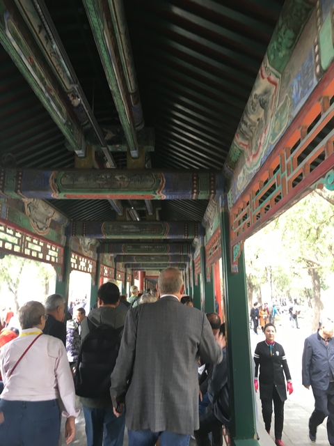 People walking under an ornately decorated corridor.