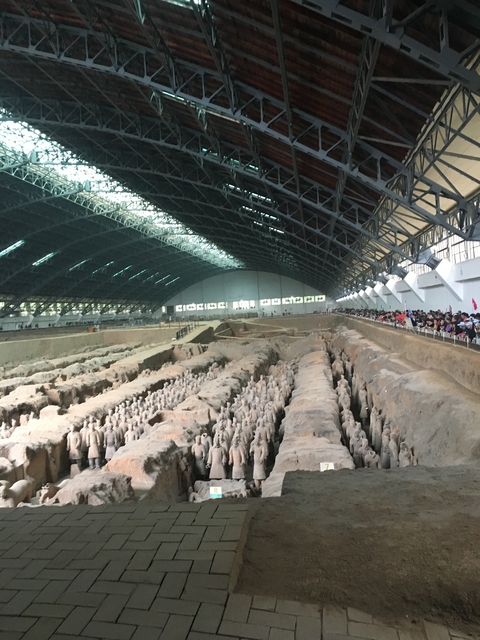       Wide view of Terracotta Warriors site with spectators.
  