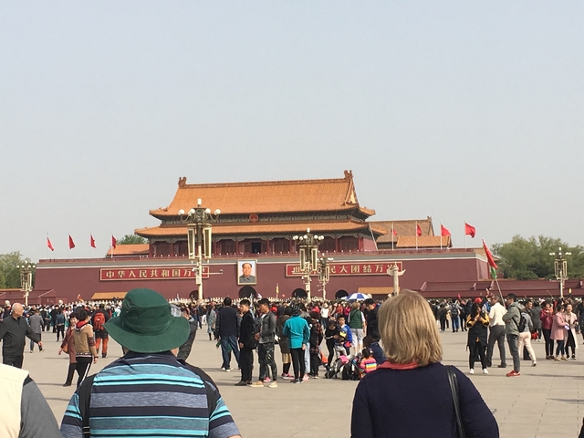 Tiananmen Square with large crowds and historical architecture.