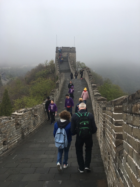      Tourists walking on the Great Wall of China enveloped in mist.
  