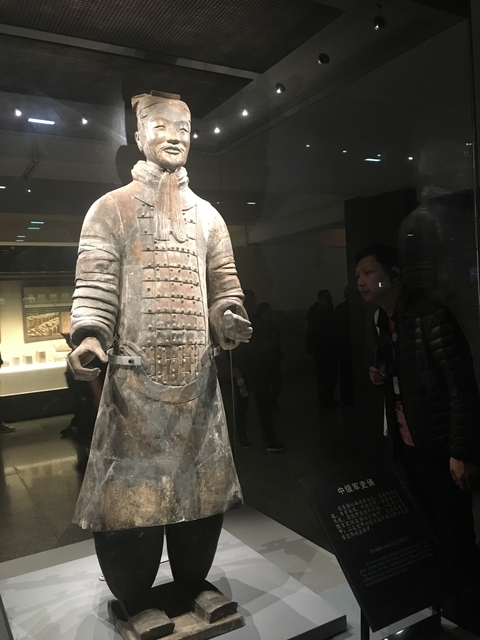       Man observing a Terracotta Warrior statue.
  