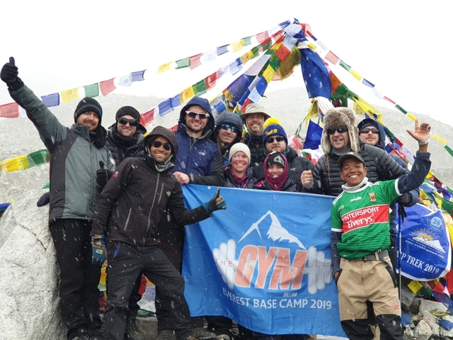       Group of trekkers with flag at a high-altitude pass
  