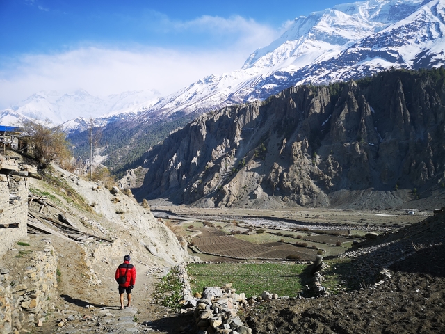 Person walking through valley surrounded by mountains