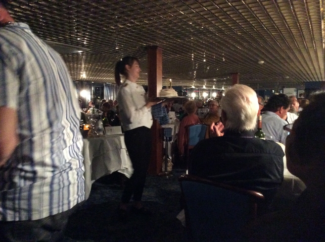       Indoor scene with people dining in a restaurant.
  