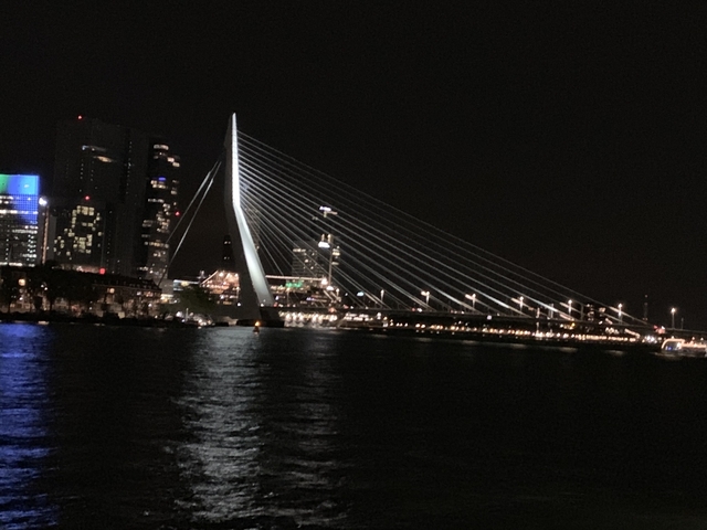       Night view of a bridge and city lights reflecting on the water.
  