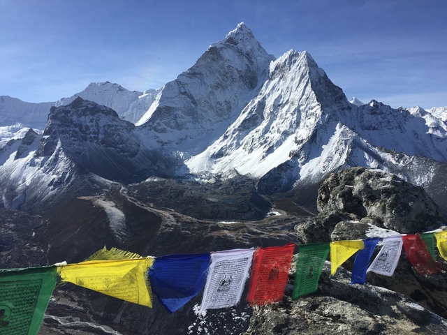 Mountain peak with prayer flags in the foreground.