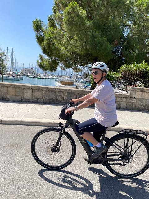       Person cycling along a scenic coastal road.
  