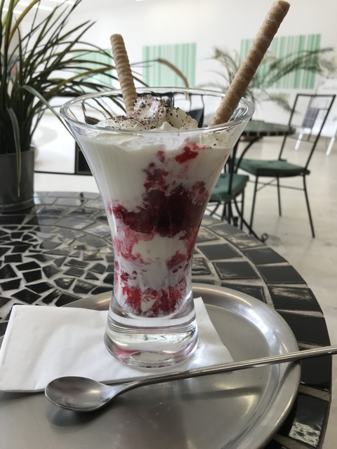       Elegant glass with a dessert containing whipped cream and berries.
  