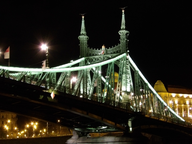 Dramatically lit suspension bridge at night.
