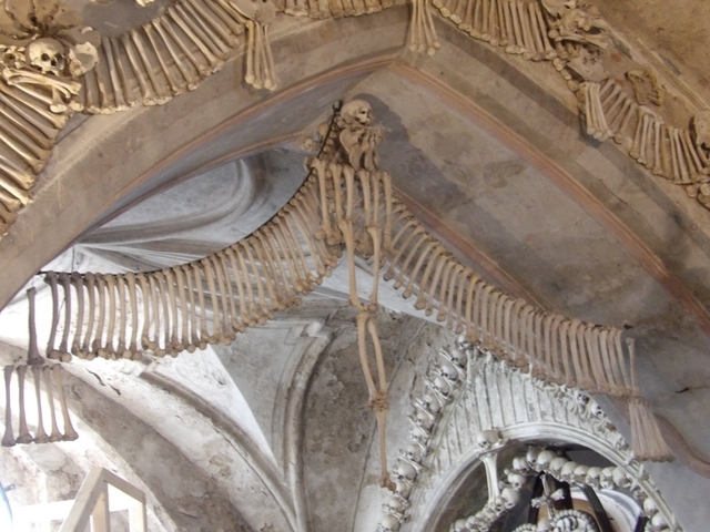 Decorative arrangement of human bones forming an archway inside a church.