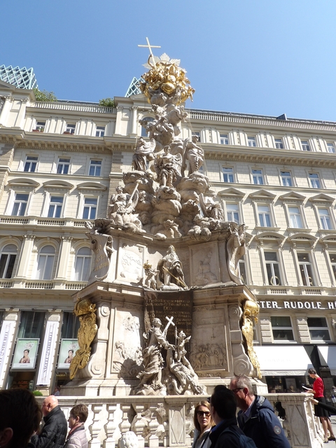       Close-up of an ornate statue in front of a classical building.
  