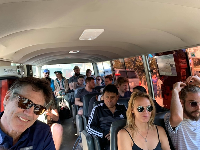       People sitting inside a minibus traveling through a city.
  