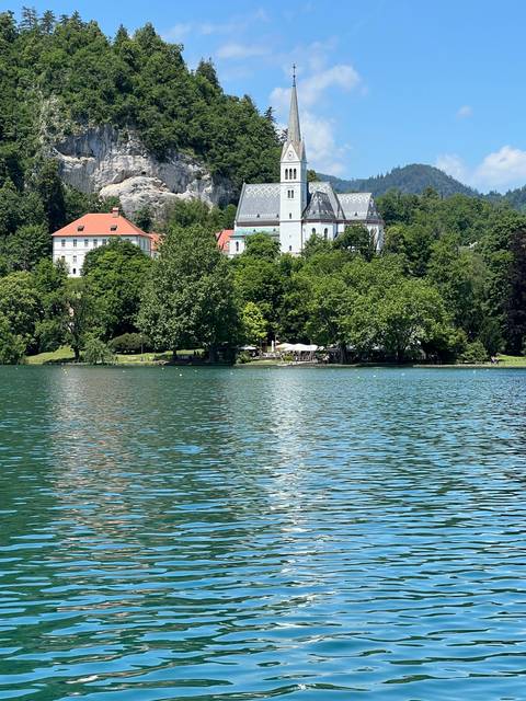 A church and buildings by a lake.