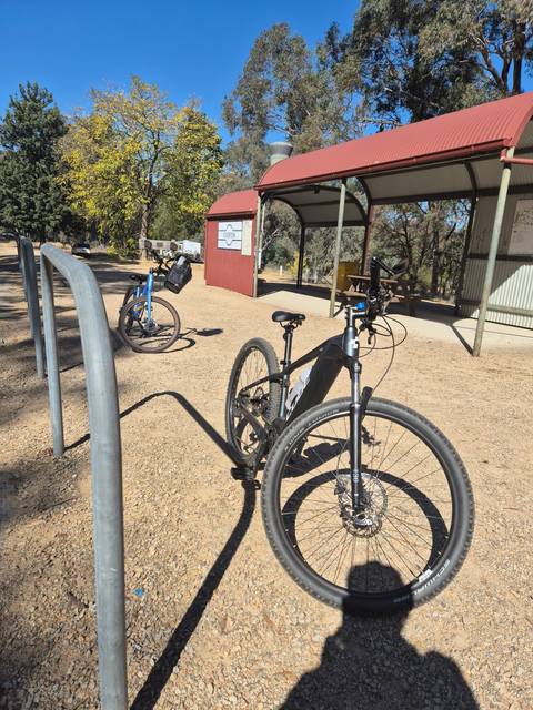 Bicycles in a park area with trees.