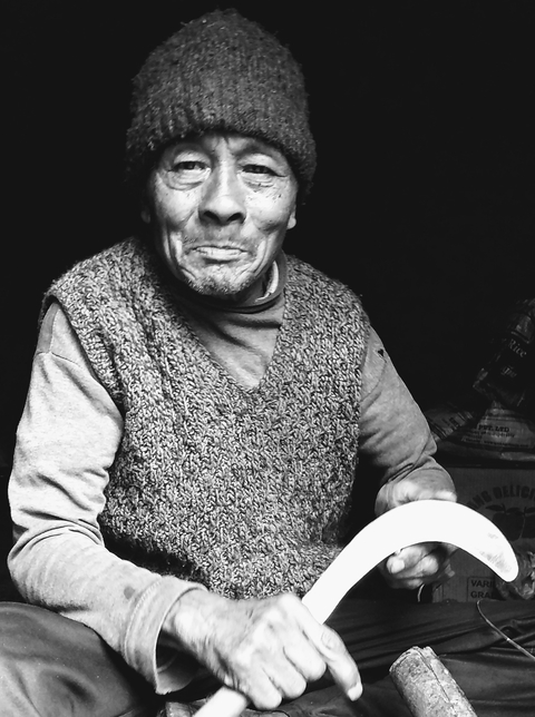 Elderly person smiling in black and white.