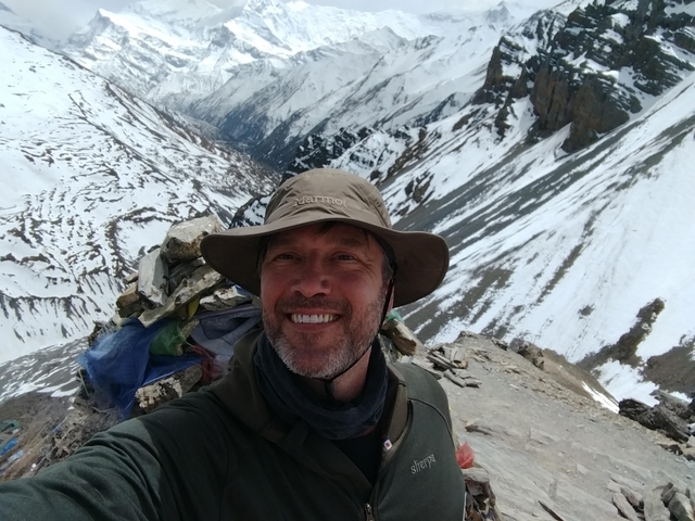 Person on a snowy mountain trail wearing a hat.