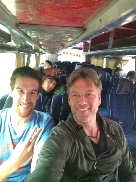       Group of people on a bus making peace signs.
  