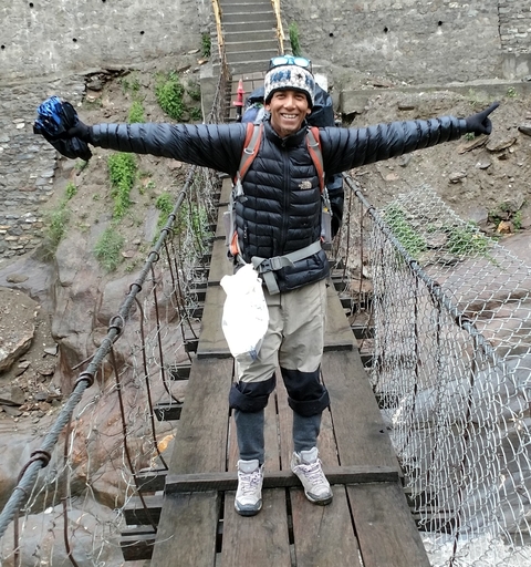       Person posing on a bridge with arms spread wide.
  