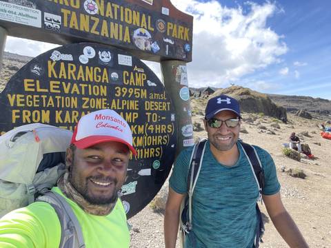 Mountaineers posing at Karanga Camp sign.