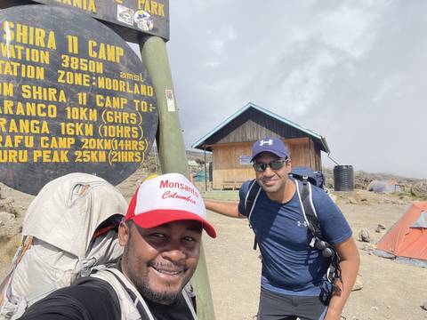 Two hikers at a campsite with Karanga Camp sign.