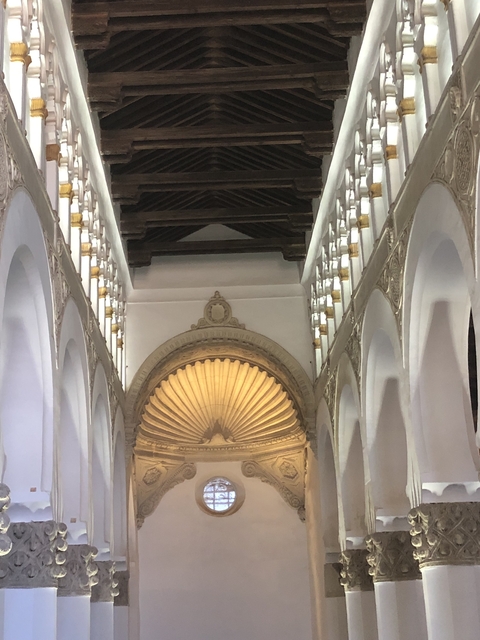 Interior of a historical building with ornate arches and ceiling.