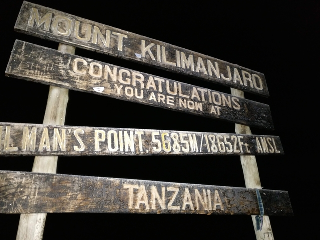 Kilamanjaro summit sign at night.