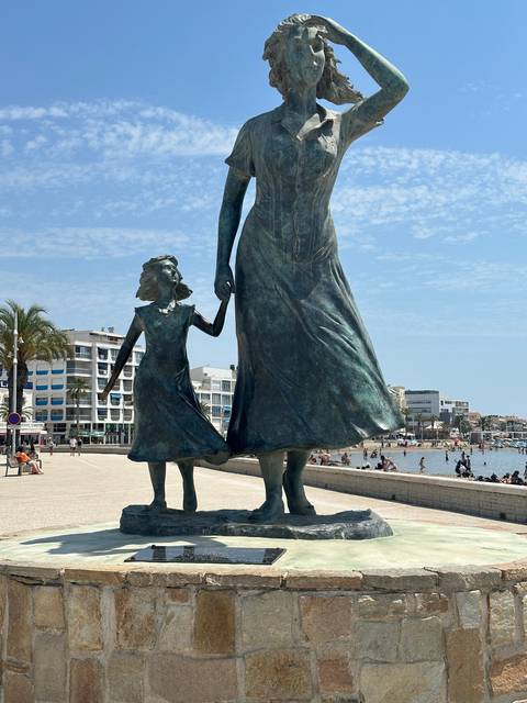 Statue of two figures holding hands.