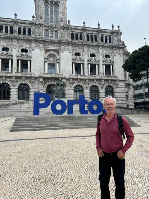 Man posing with the Porto sign in the background.