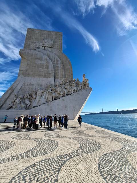 A monument with intricate sculptures by the sea.