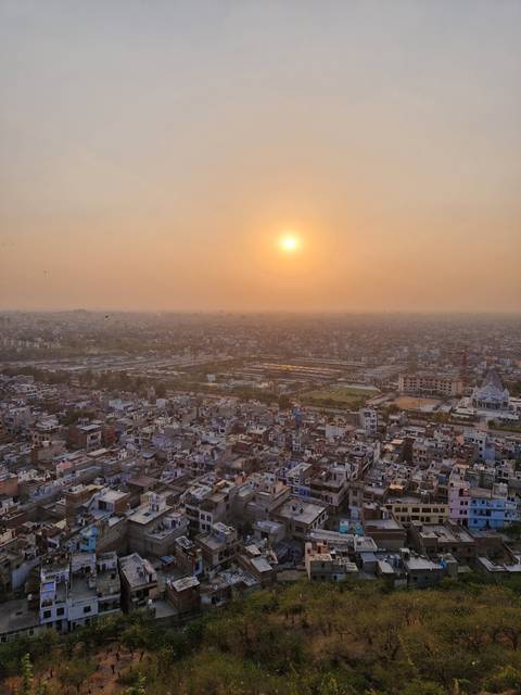 Sunset over a sprawling urban landscape with a clear sky.