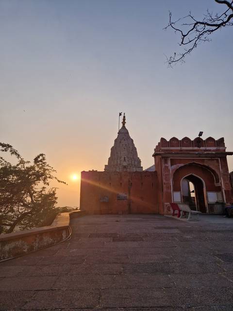       Temple silhouette against a dramatic sunset sky.
  