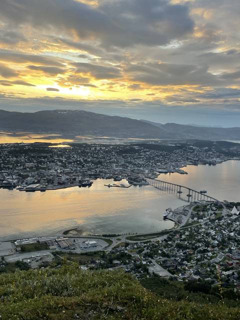       Aerial cityscape view with a bridge over water during sunset.
  
