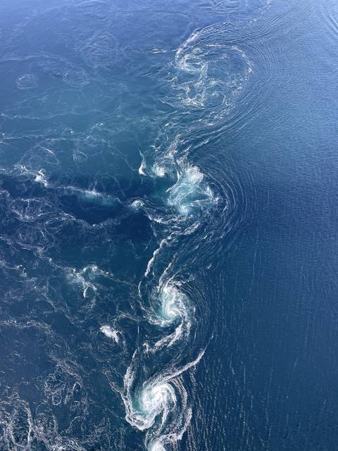 Aerial view of oceanic whirlpools with swirling patterns.