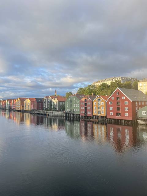 Colorful buildings along a river with reflections in the water.