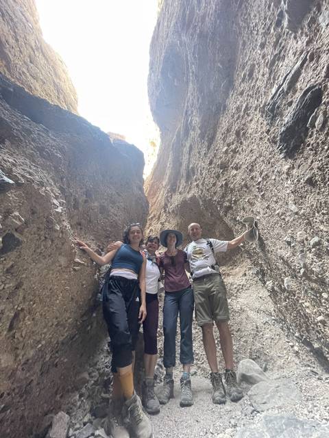       A group of people standing inside a rock formation.
  