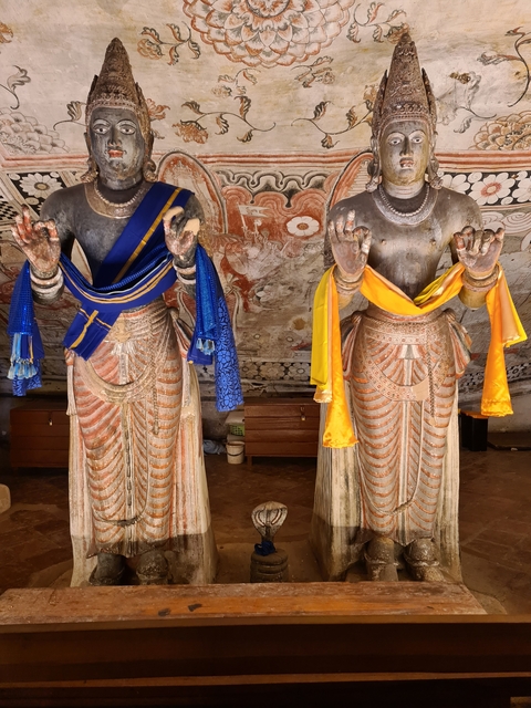       Ornate statues adorned with colorful fabric.
  