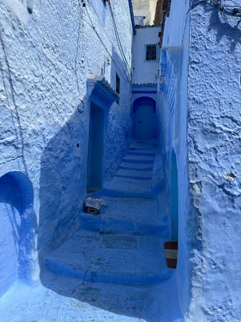       Narrow blue alley with a stairway.
  