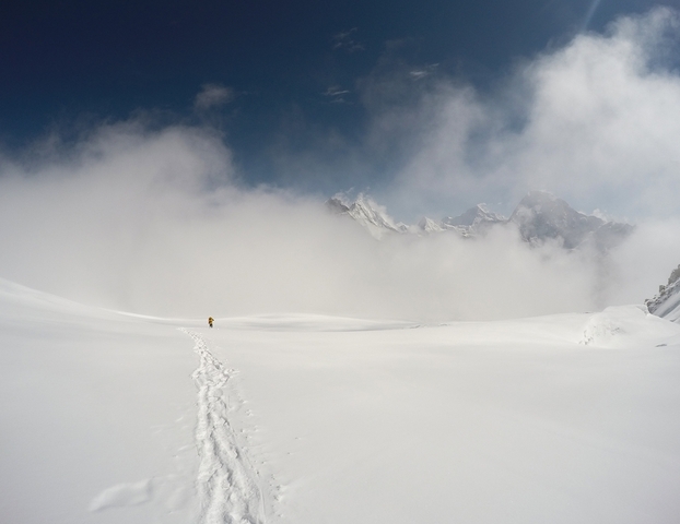       Snowy landscape with a solitary figure and mountains hidden in mist.
  