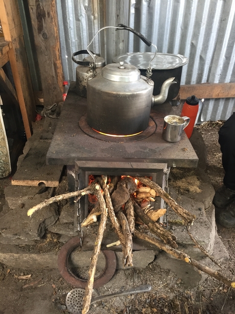 Wood-burning stove with pot and kettle.