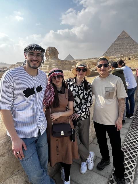       Group of people posing with the Sphinx in the background.
  