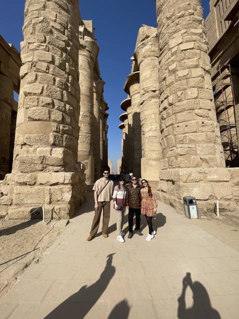       People posing among ancient Egyptian ruins.
  