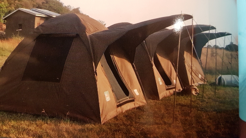       Row of tents set up in a field.
  
