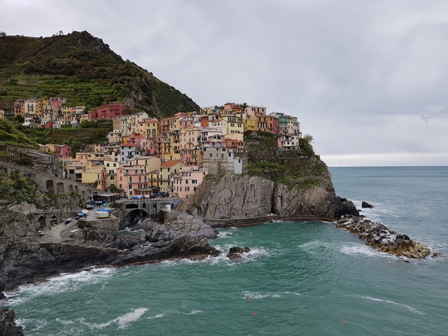 Colorful houses on a cliff overlooking the sea in a coastal village.