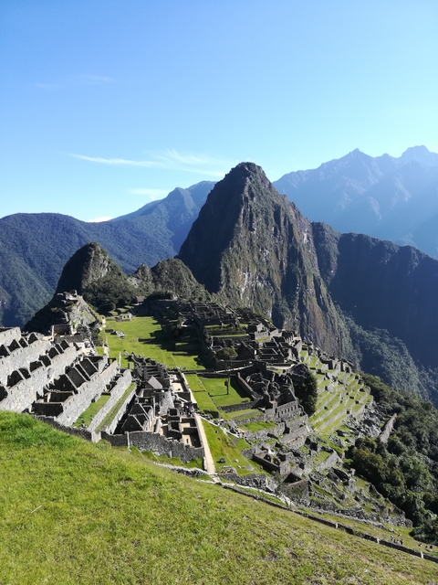       Panoramic view of Machu Picchu with mountains in the background.
  