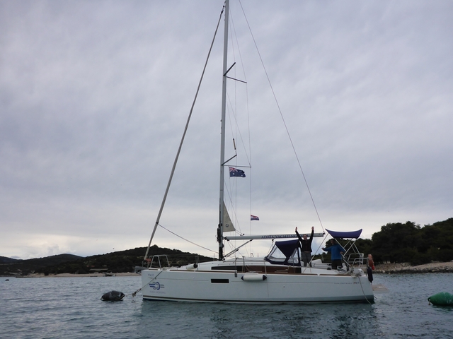 Sailboat with visible flags on a cloudy day.
