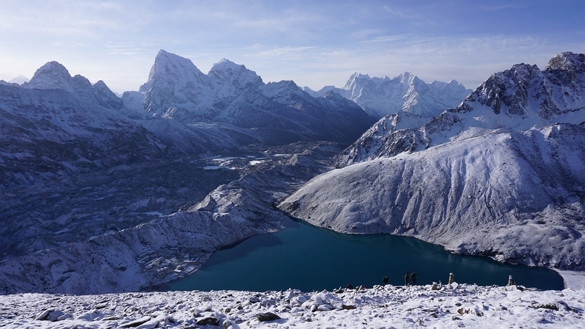 Snow-covered mountains and a lake in the Himalayas.